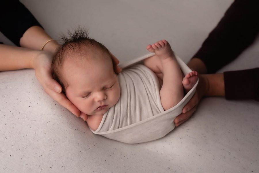 wrapped-newborn-parents-hands-posed-baby-photography-session-1