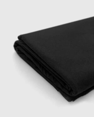 Wrinkle‑free black posing fabric used with beanbag for timeless newborn photography