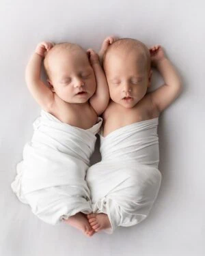Newborn baby twins posed on soft white jersey backdrop Molly during a photo session