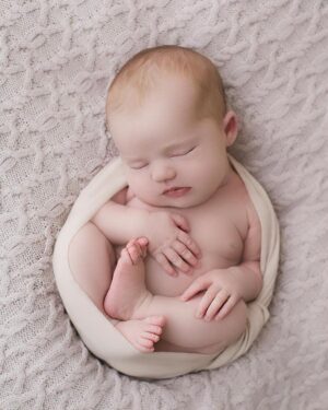 Baby girl wrapped in the Molly blush swaddle during a newborn photography session