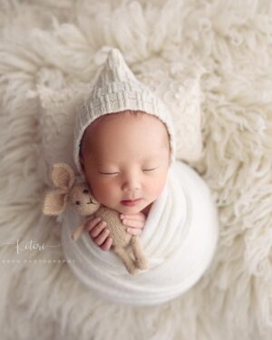 Baby boy posed in knitted pixie hat for professional newborn photography