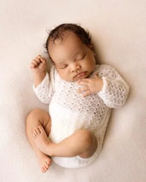 Baby boy wearing long‑sleeve knitted romper in cream