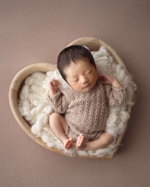 Baby posed in earth tones romper for professional newborn photography